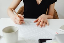 A writer at her desk, with pen and papers